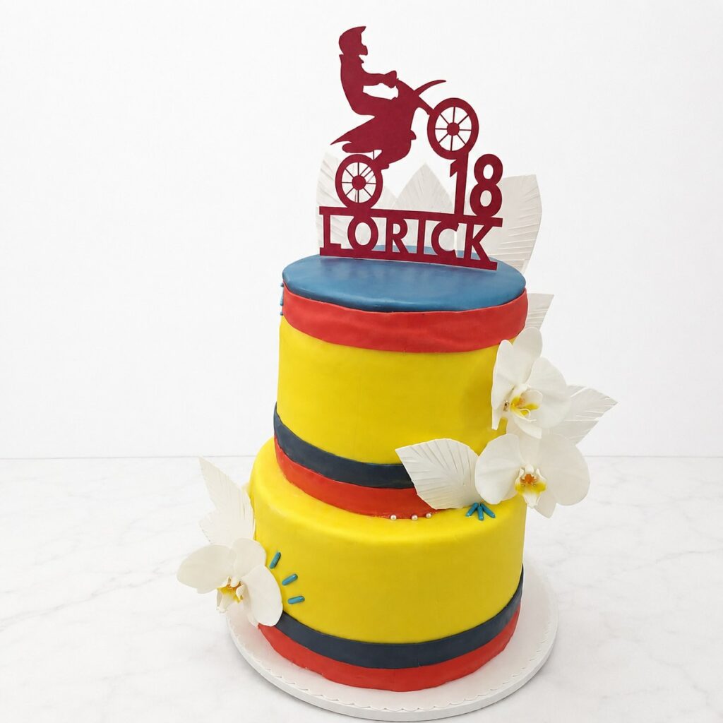 Cake design à deux étages aux couleurs de la Colombie sur le thème du motocross