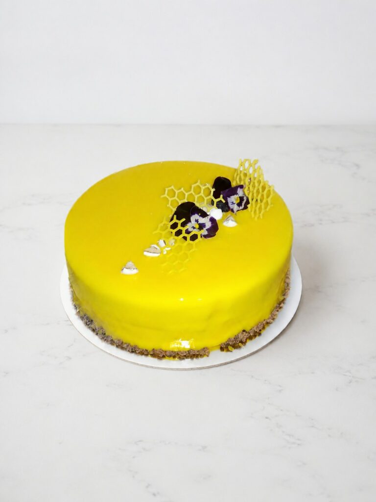 Entremets jaune au glaçage miroir, décor nid d’abeille et fleurs