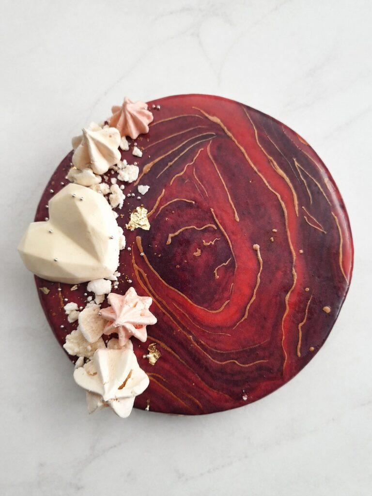 Entremets rouge marbré décoré d’un cœur blanc