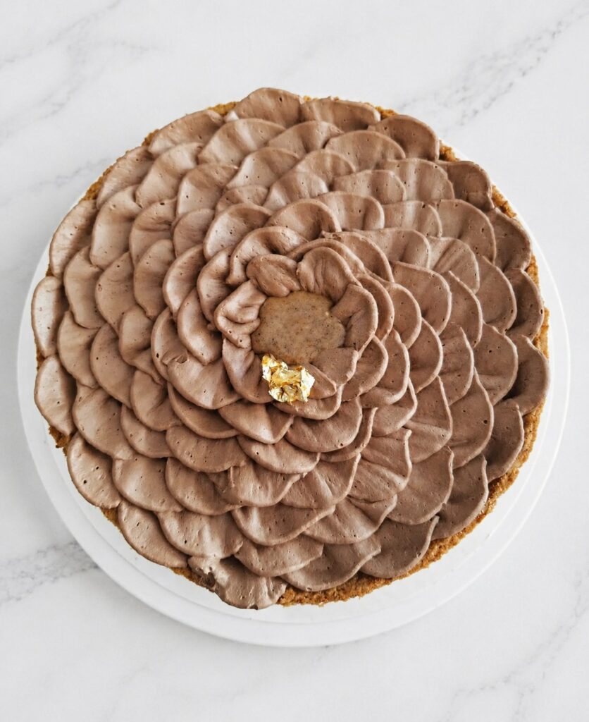 Tarte au chocolat décorée d’un pochage en pétales et d’une touche dorée
